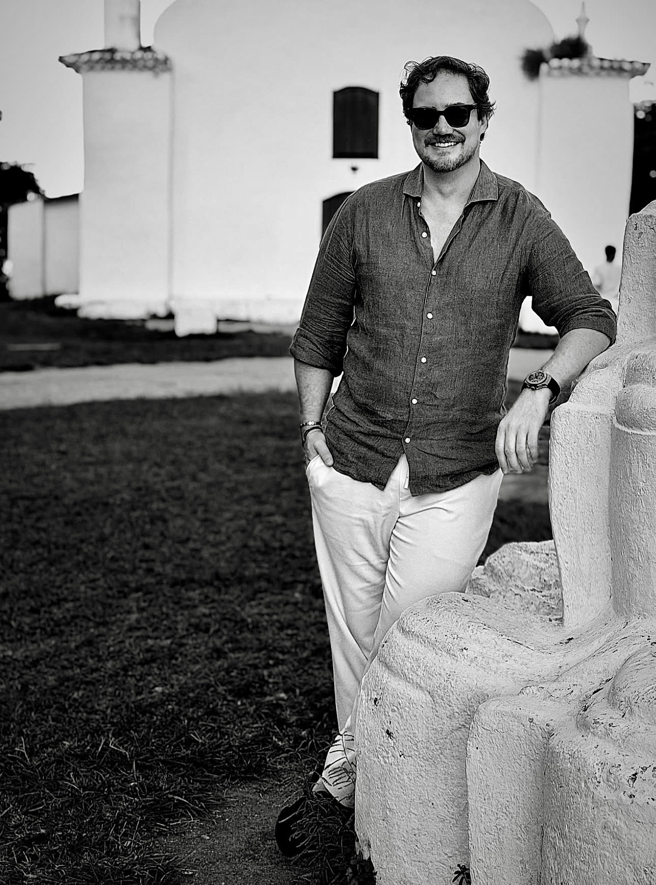Retrato em preto e branco de Rodrigo Kich, diante de uma construção histórica